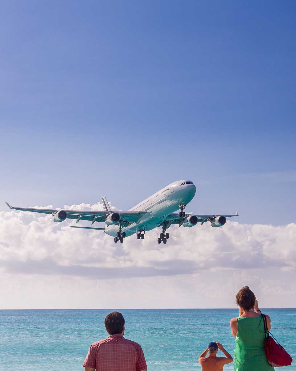 A plane flies over Maho Beach on a tour from Philipsburg St Maarten