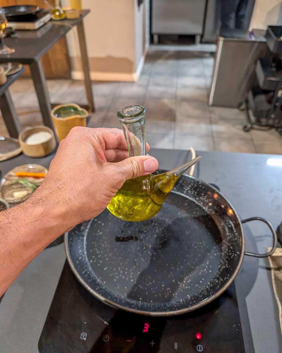 Daniel-puts-oil-in-a-pan-during-a-Paella-making-class-in-Seville-Spain
