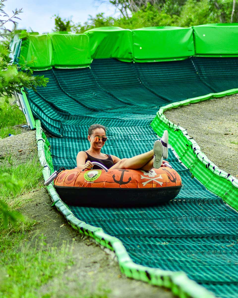 Rainforest Adventures St Maarten a person going down a slide in St Maarten