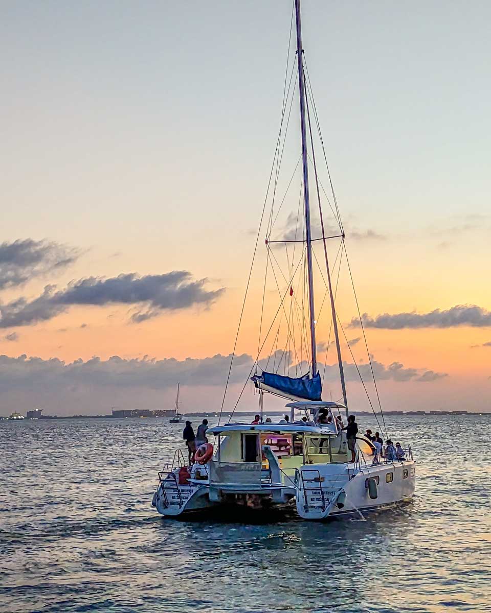 A catamaran during sunset on a tour from Mykonos Greece