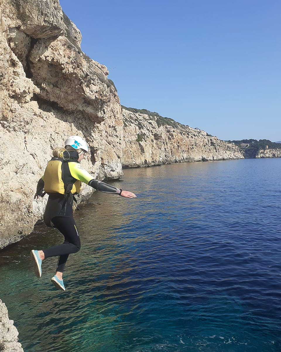 A woman cliff jumping on a tour near Palma de Mallorca Spain