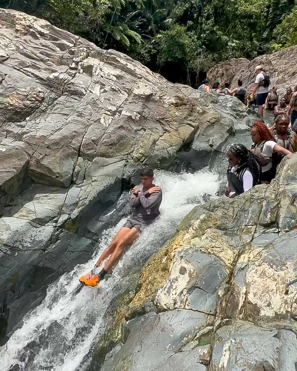 spotinpr a man goes down a natural waterslide in Fajardo Puerto Rico