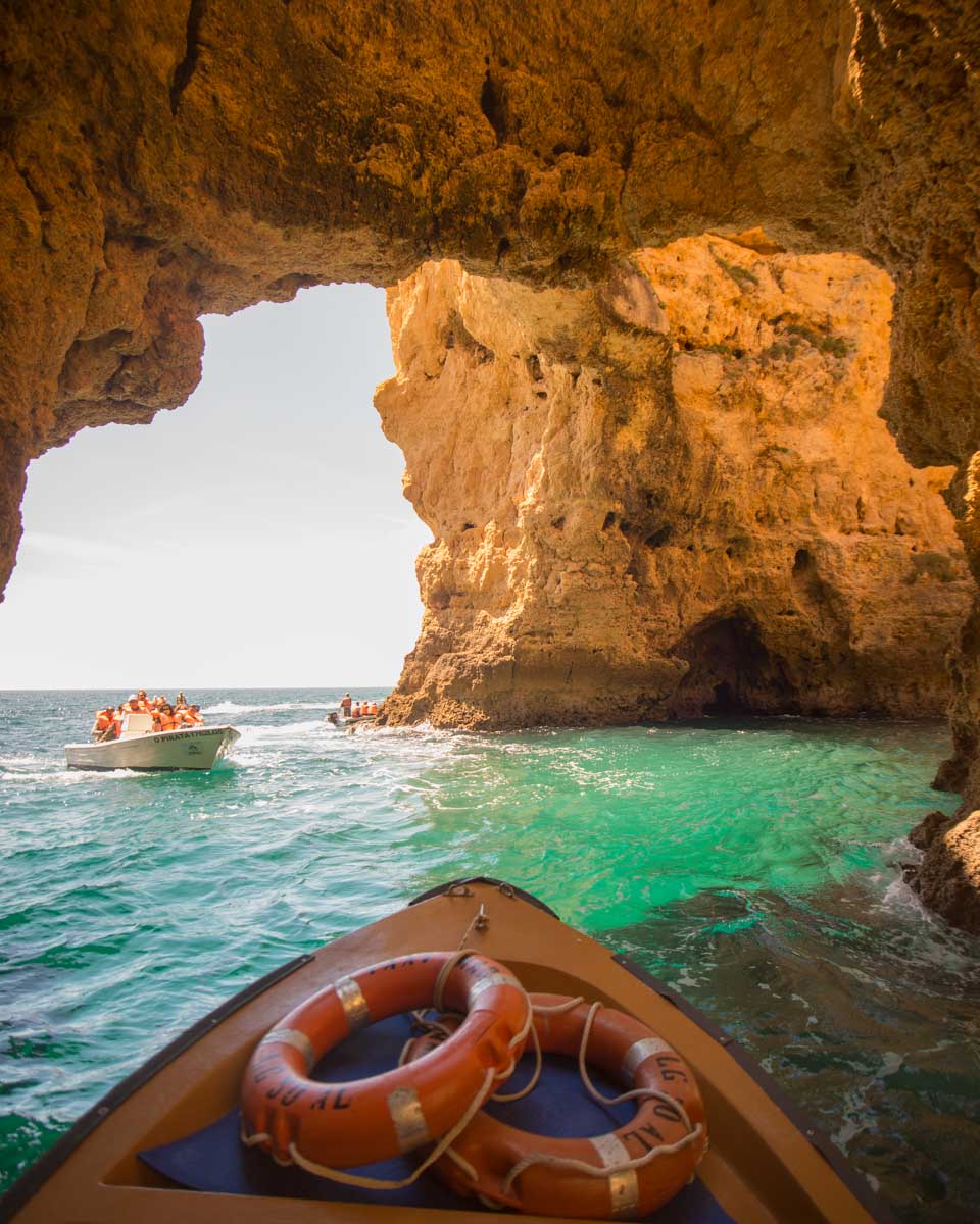 A boat goes through the rocks at Ponta da Piedade on a tour from Lagos Portugal