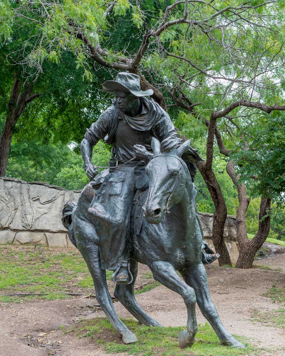 A broze sculpture of a cowboy in pioneer plaza Dallas Texas