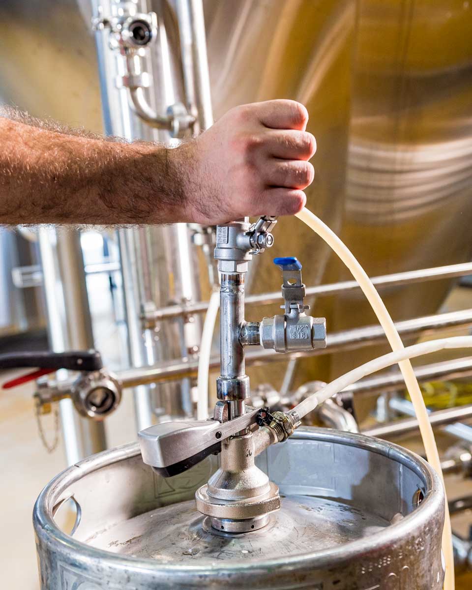 A man fills a keg on a craft beer tour in Mykonos Greece