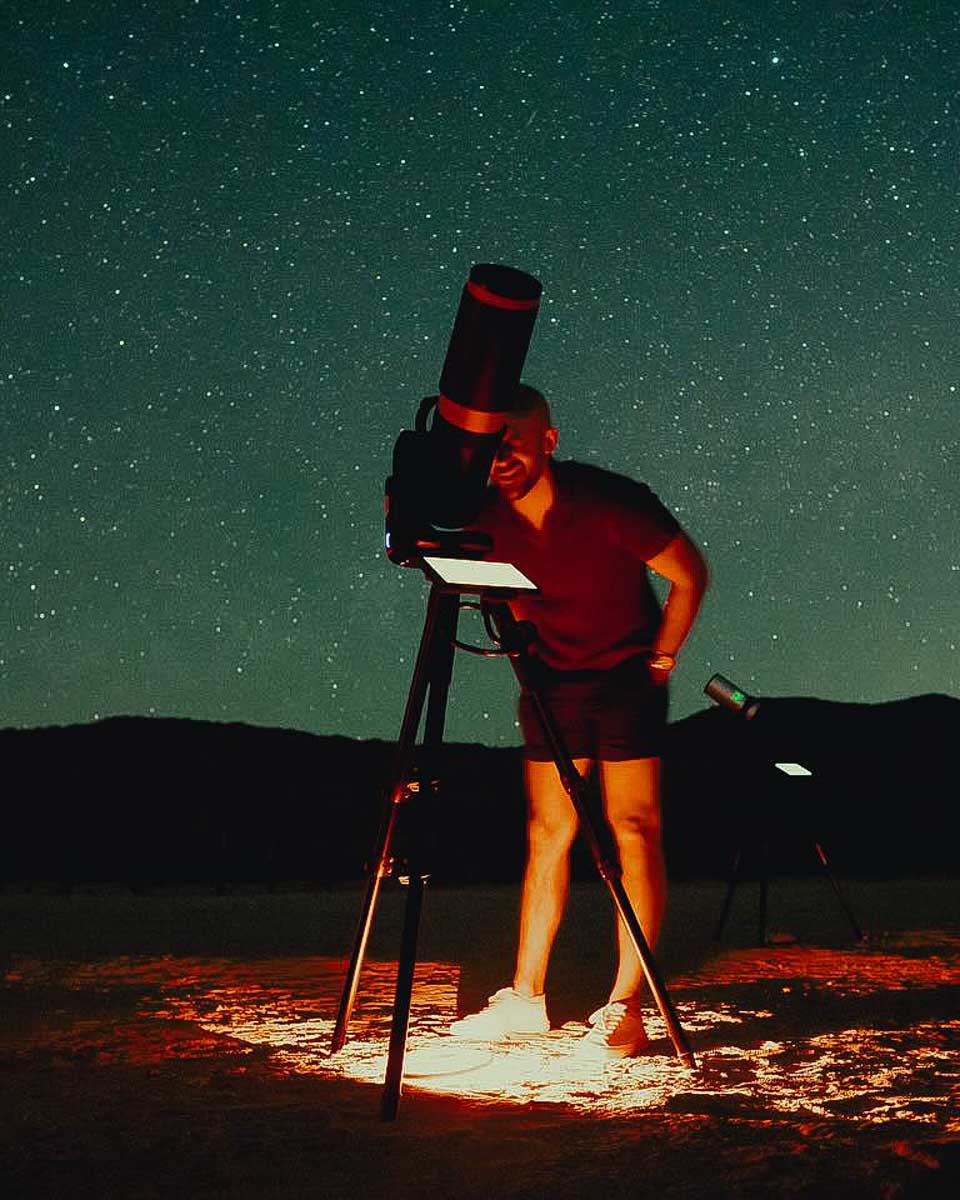 A man looks through a telescope in Joshua Tree National Park on a stargazing tour