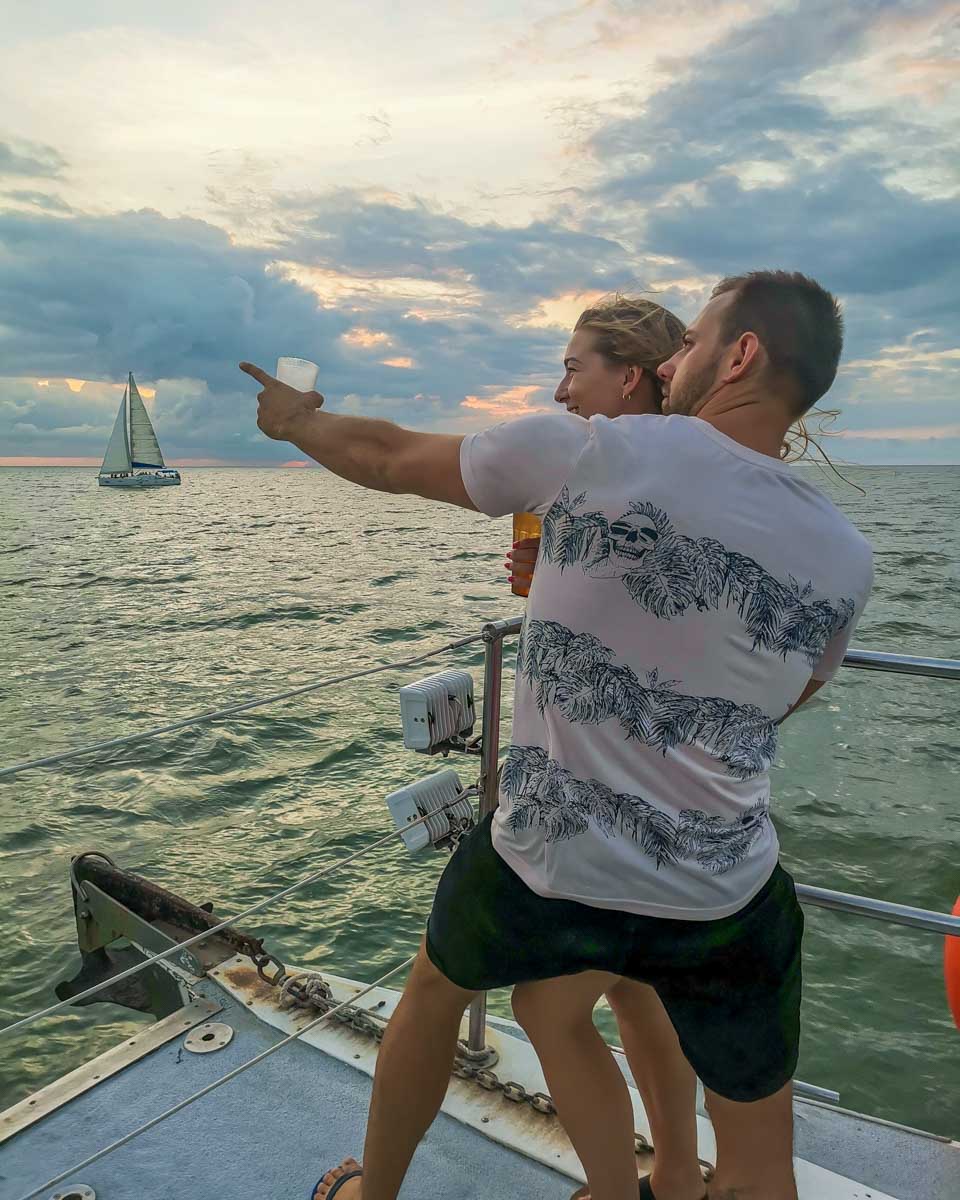 Daniel-points-to-something-while-holding-Bailey-on-a-sunset-cruise-in-Key West Florida