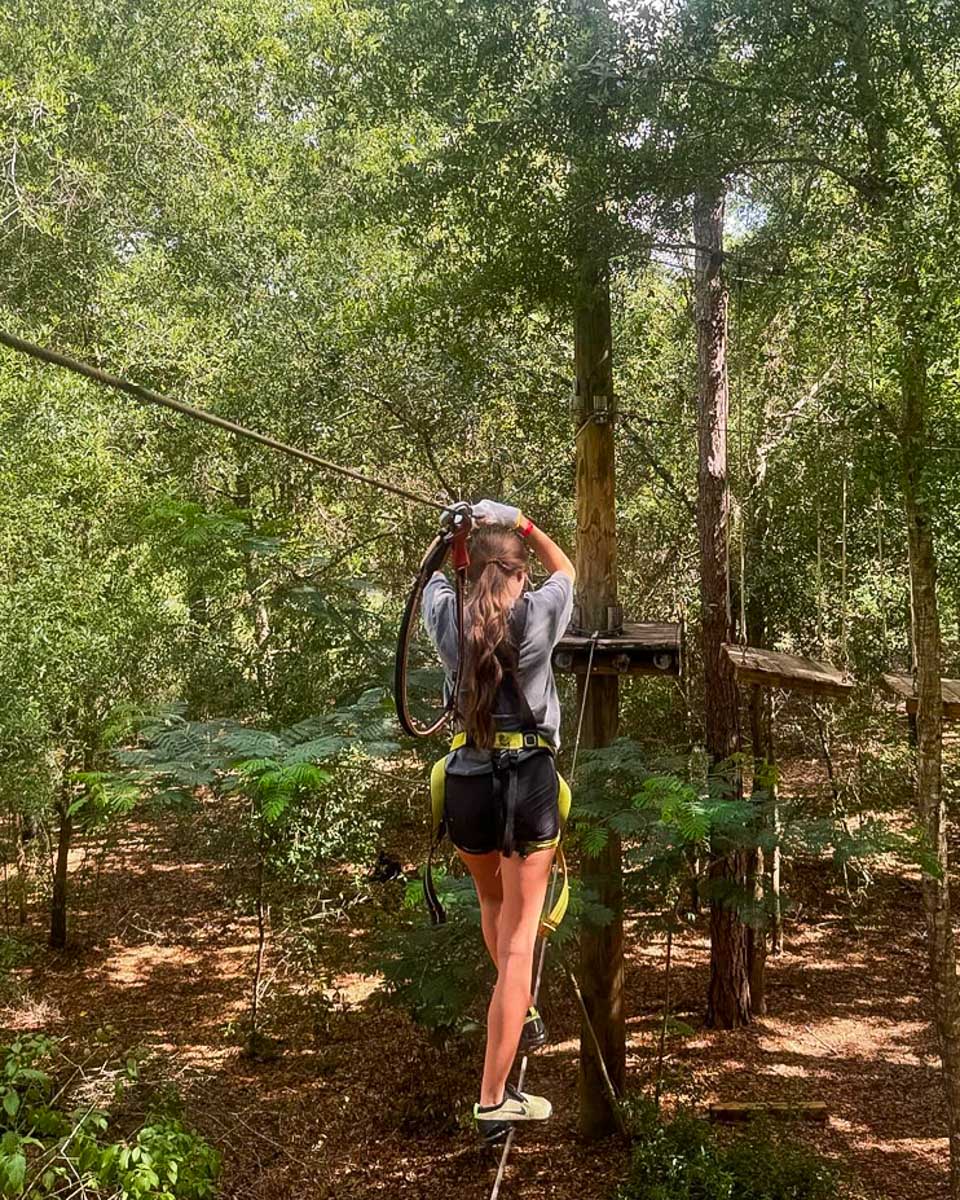 Orlando Tree Trek Adventure Park a woman walks across a wire in Orlando Florida