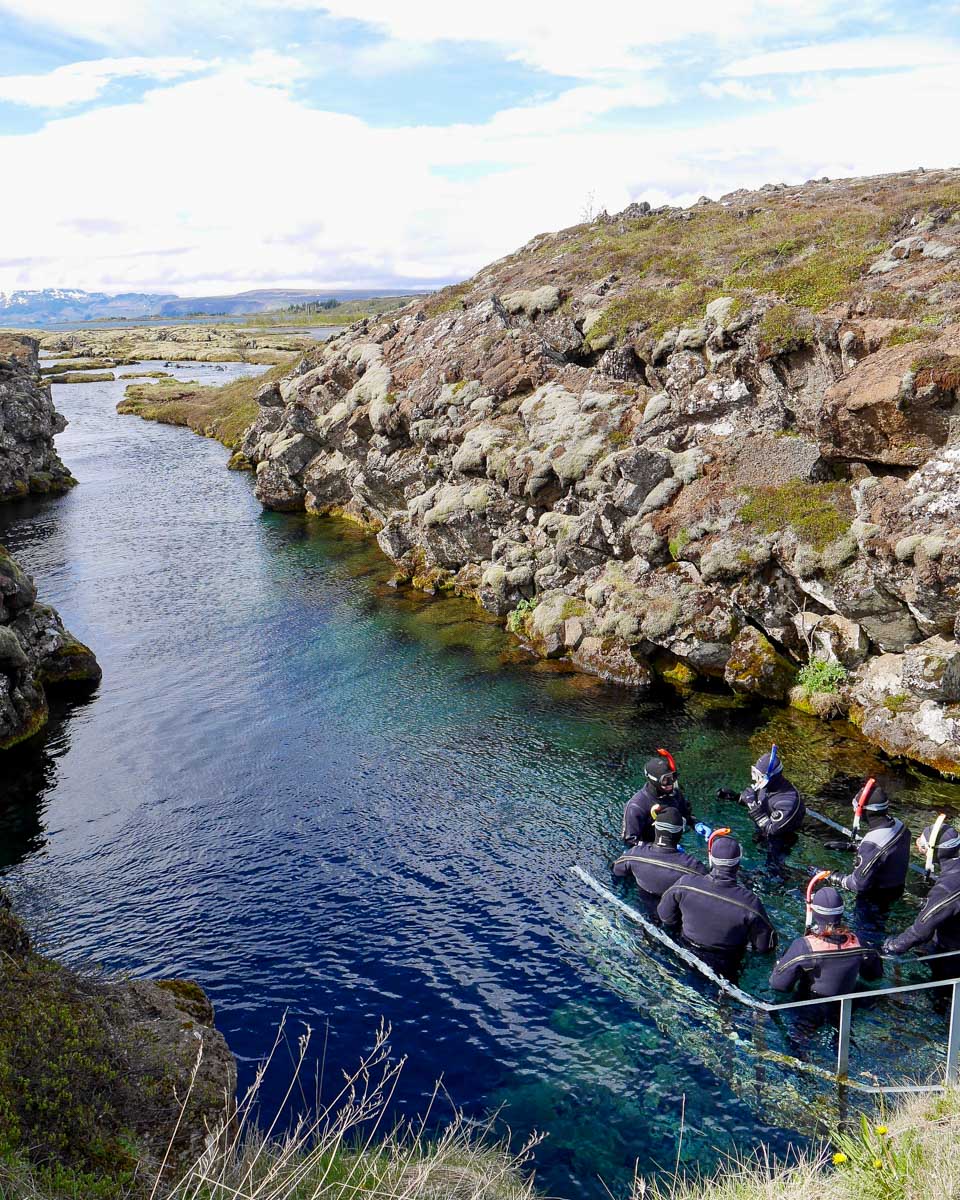 People snorkel at Silfra Rift in Reykjavik Iceland