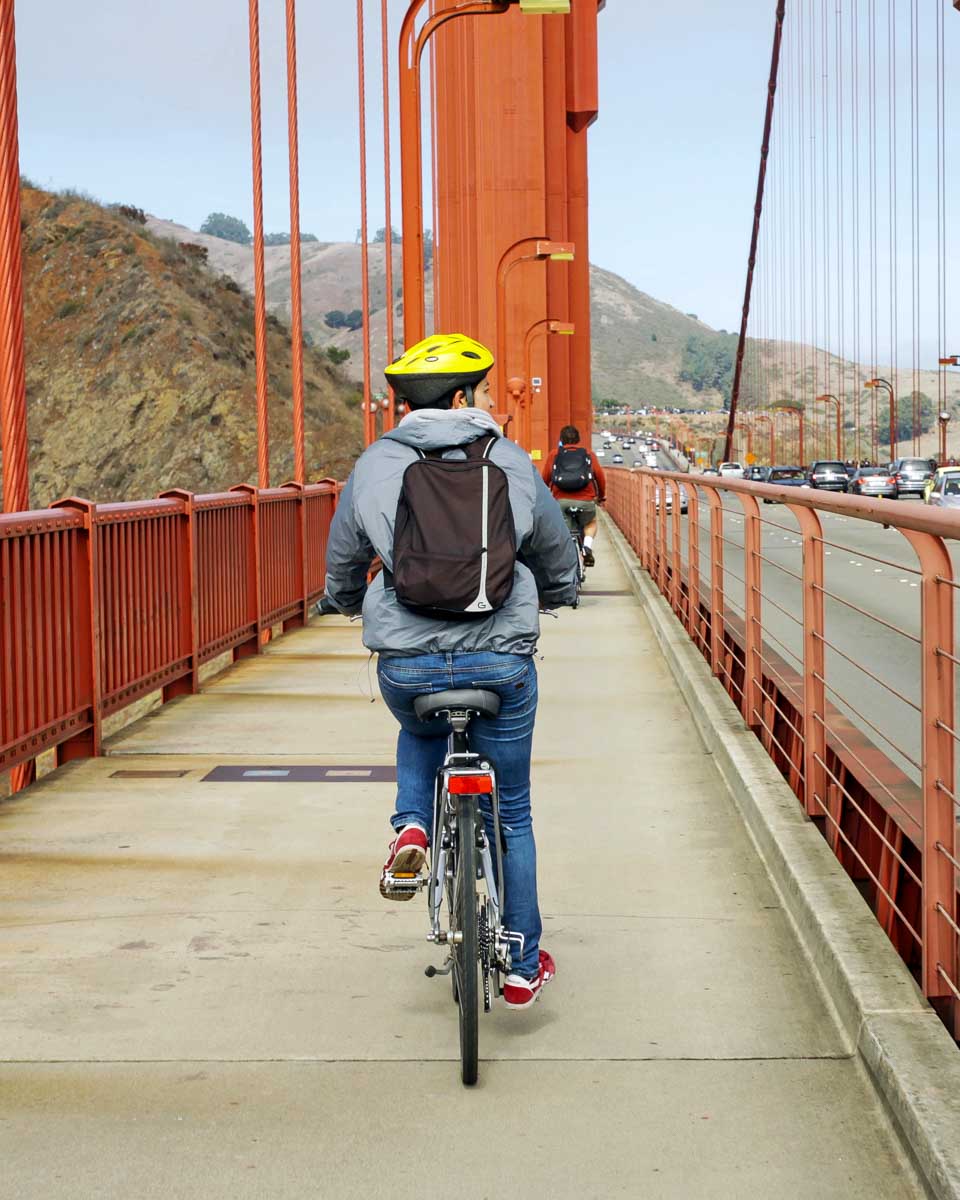 A person rides a bike across the Golden Gate Bridge in San Francisco California