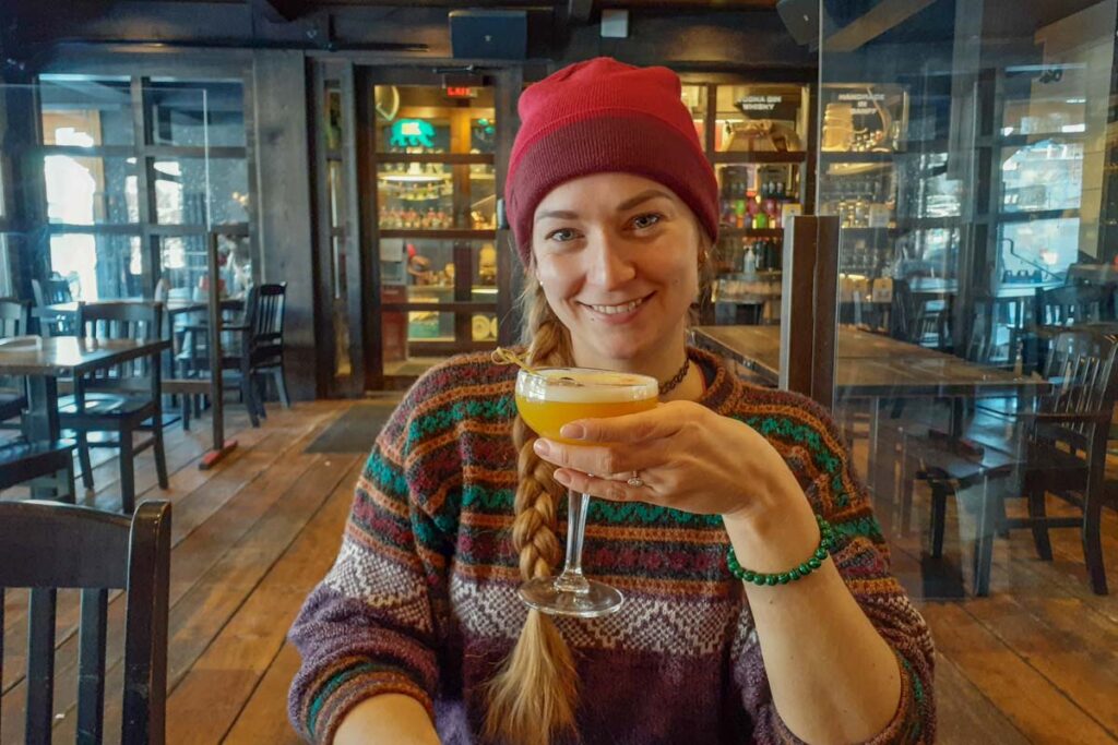 Bailey drinks a cocktail Park Distillery Restaurant and Bar in Banff Alberta