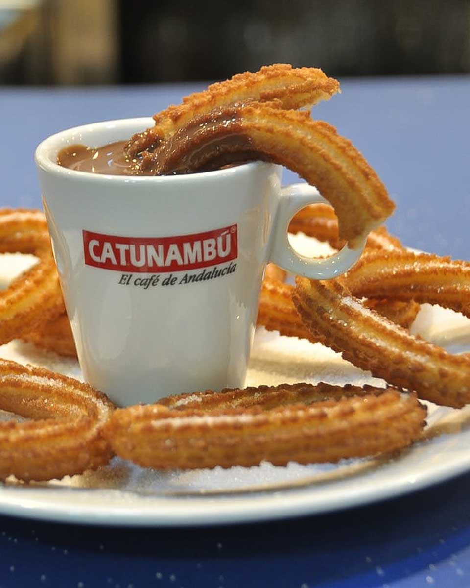 Churro in a dip at Cafeteria Catunambu in Seville Spain