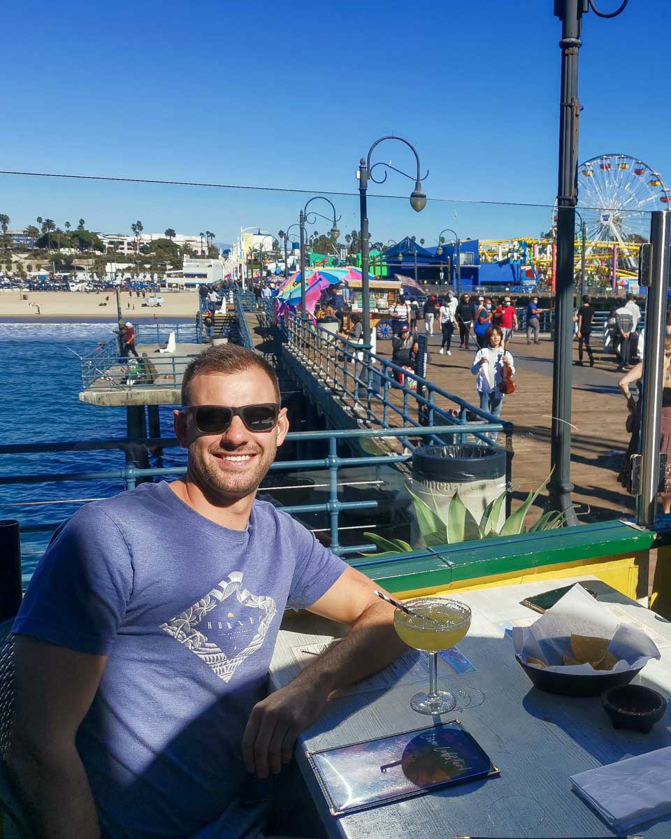 Daniel drinks a cocktail on Santa Monica Pier Los Angeles California