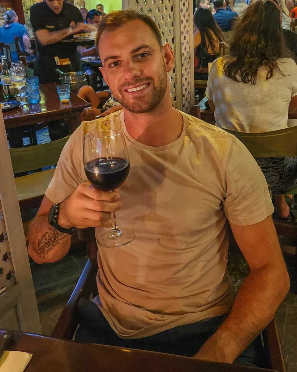 Daniel-enjoys-a-glass-of-wine-during-dinner-in the neighborhood of Koukaki in Athens Greece