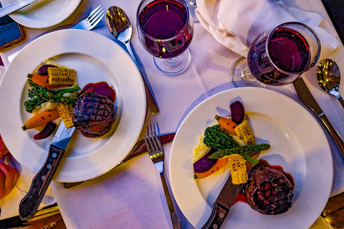 Steak dinners and wine on a table in Seville Spain