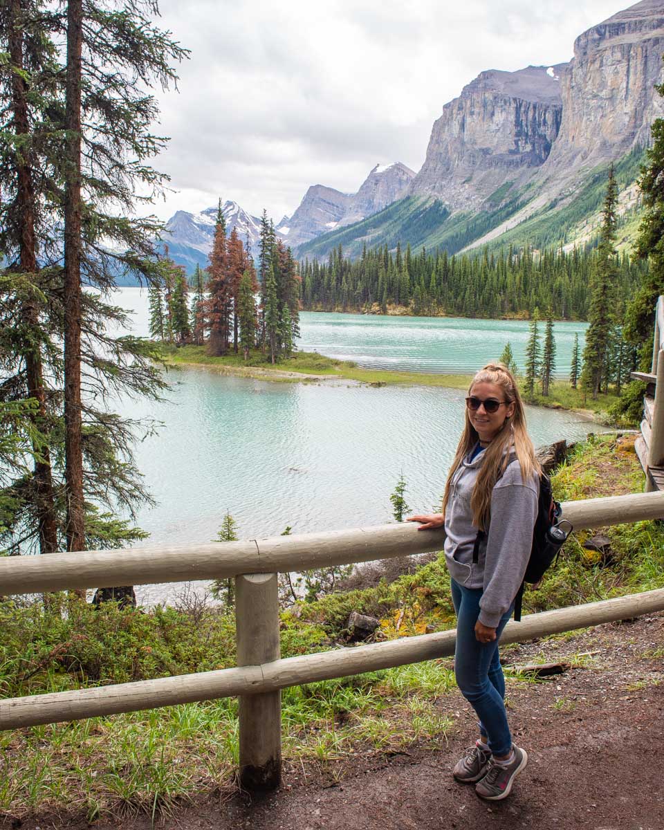 Bailey-poses-for-a-photo-at-Maligne-Lake-looking-over-at-Spirit-Island on a tour from Jasper
