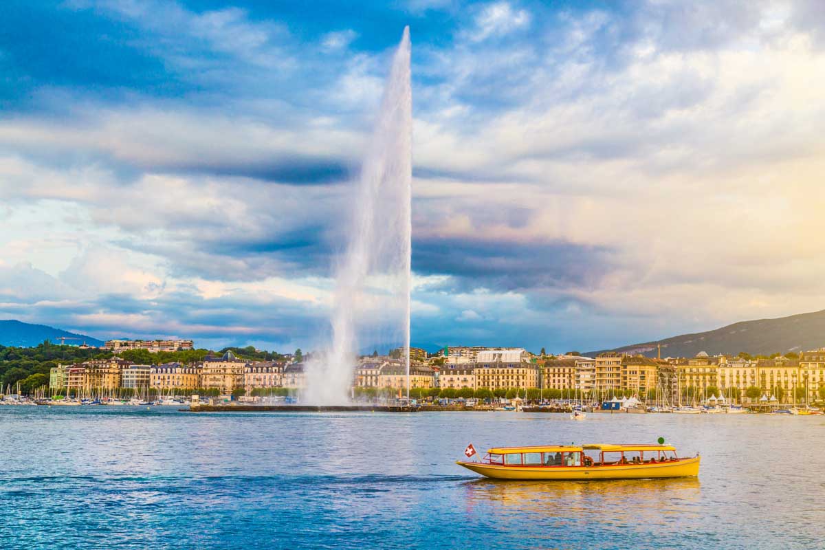 City of Geneva with famous Jet d'Eau fountain at sunset