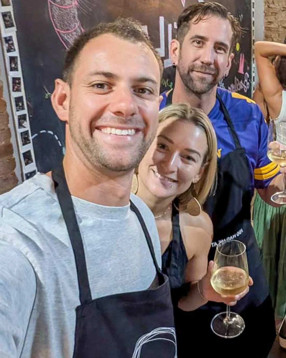Daniel-and-Bailey-smiling-in-a-kitchen-during-a-cooking-class-in Spain