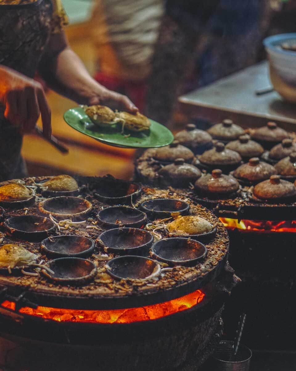 A person in Ho Chi Minh Vietnam makes street food at night
