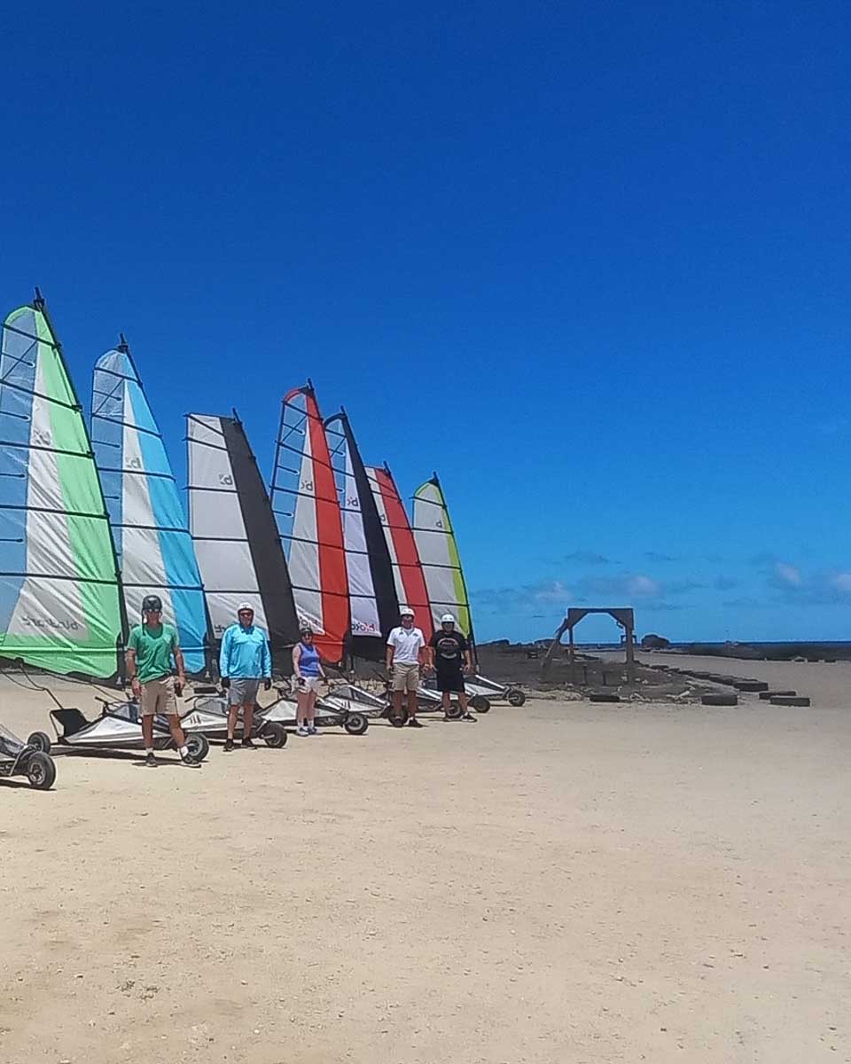 A group of people pose for a picture before landsailing with Bonaire Landsailing Adventures