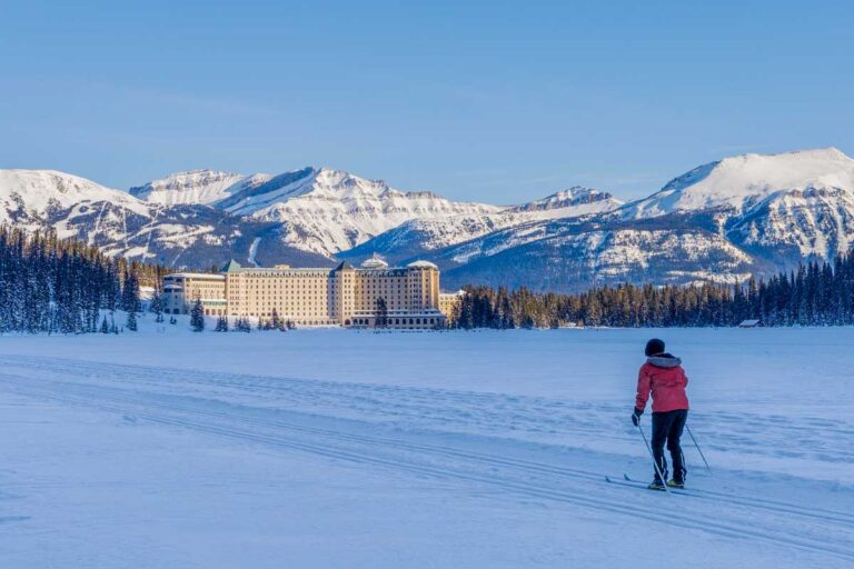 Tourist skating on Lake Louise winter trail in Canada