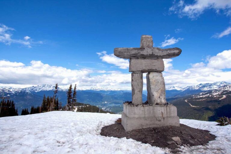 Whistler Peak inukshuk with snow and mountains in Whistler Canada